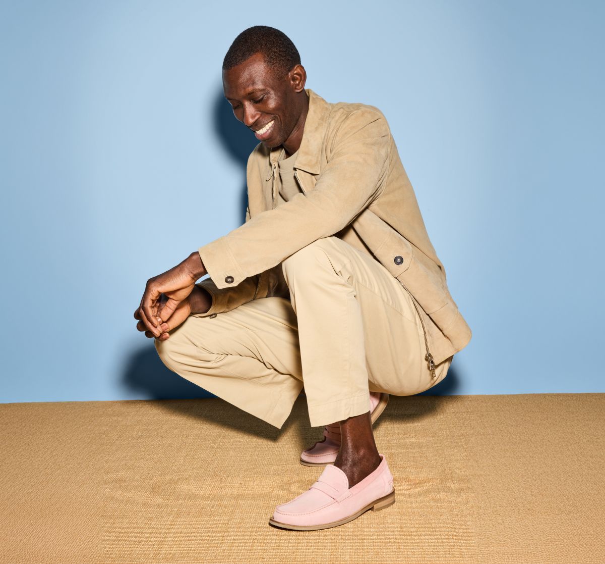Light pink suede Allen Edmonds Sorrento penny loafers worn by a man with cream socks and khaki trousers. 